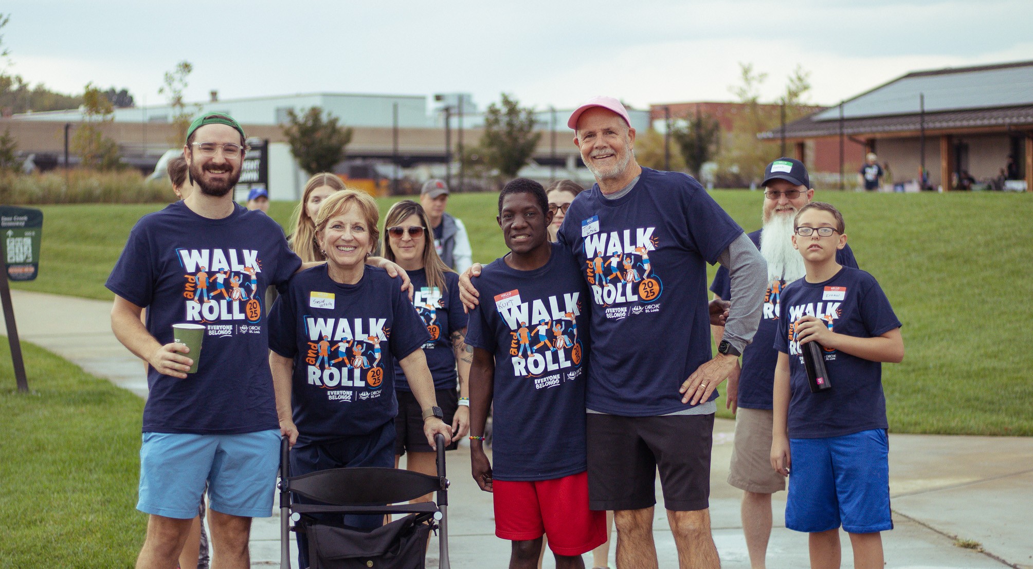 Individuals with and without disabilities in Walk and Roll t-shirts pose for a p